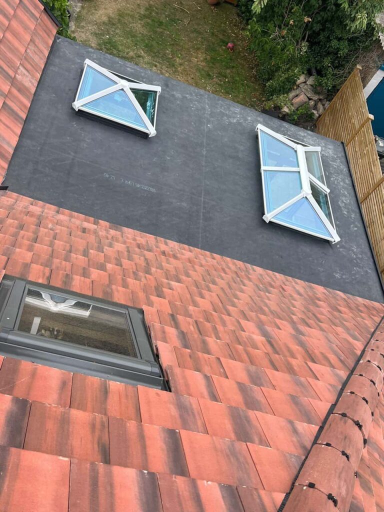 This is a photo taken from the roof ridge looking down a tiled pitched roof on to a flat roof. Works carried out by TRP Roofing Brough